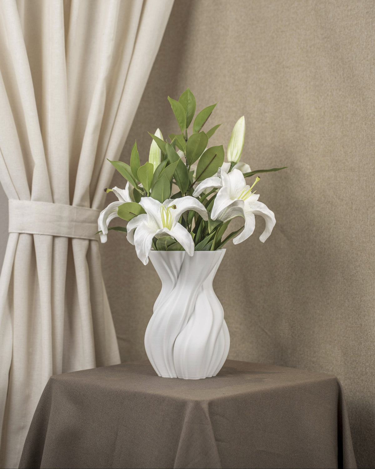 Vintervad Design Anna white sculptural vase with organic tree-inspired lines, holding white lilies on a brown table.