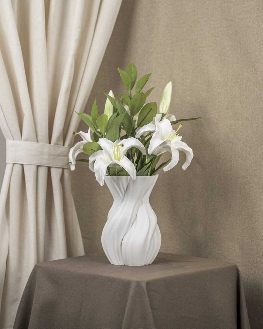 Vintervad Design Anna white sculptural vase with organic tree-inspired lines, holding white lilies on a brown table.