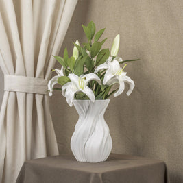 Vintervad Design Anna white sculptural vase with organic tree-inspired lines, holding white lilies on a brown table.