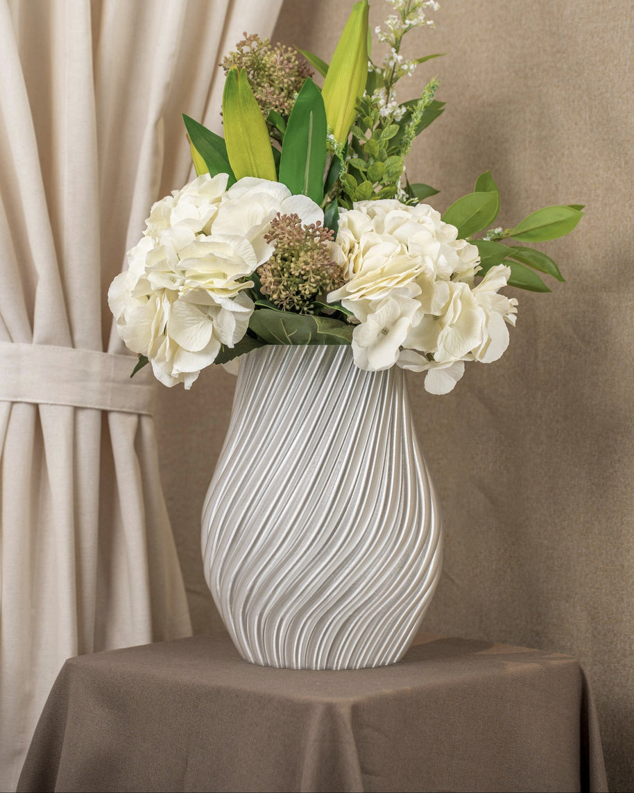 Vintervad Design Ida vase in clear, featuring a modern spiral texture, filled with a bouquet of white flowers.