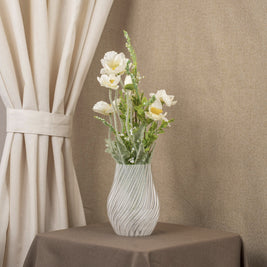 Vintervad Design Ida vase in clear, eco-friendly material with spiral details, holding a bouquet of white flowers.