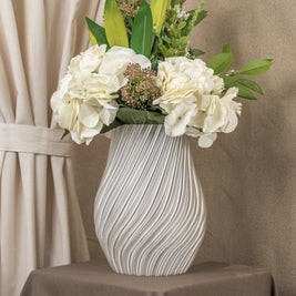 Vintervad Design Ida vase in clear, featuring a modern spiral texture, filled with a bouquet of white flowers.