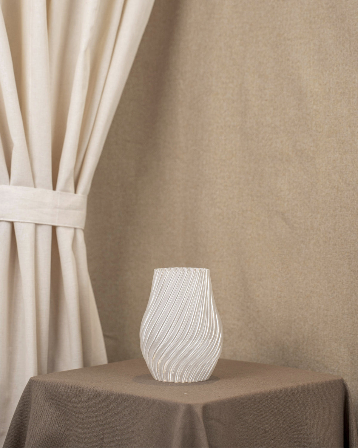 Vintervad Design Ida vase in clear, biodegradable material with elegant spiral patterns on a brown table.