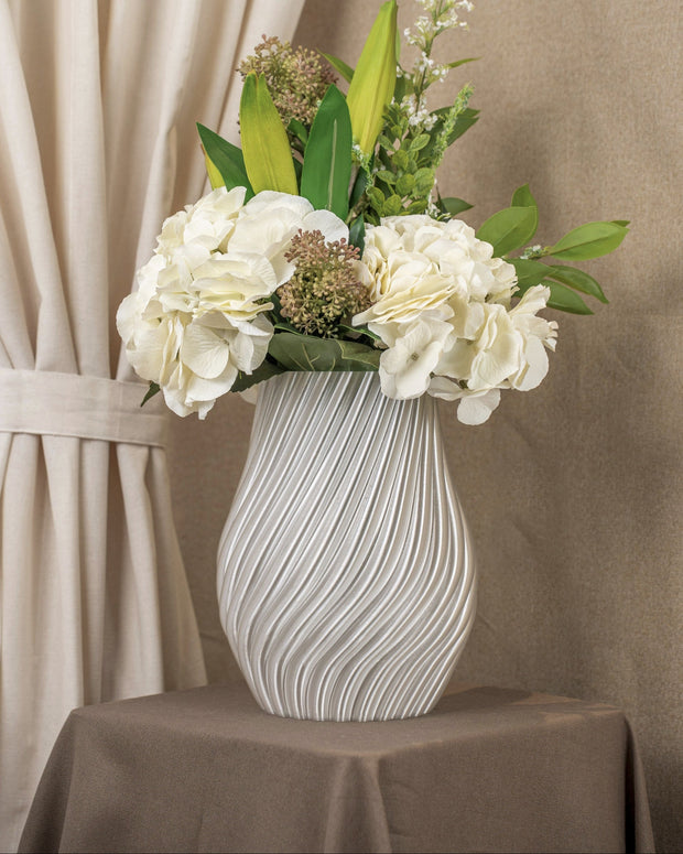 Vintervad Design Ida vase in clear, featuring a modern spiral texture, filled with a bouquet of white flowers.