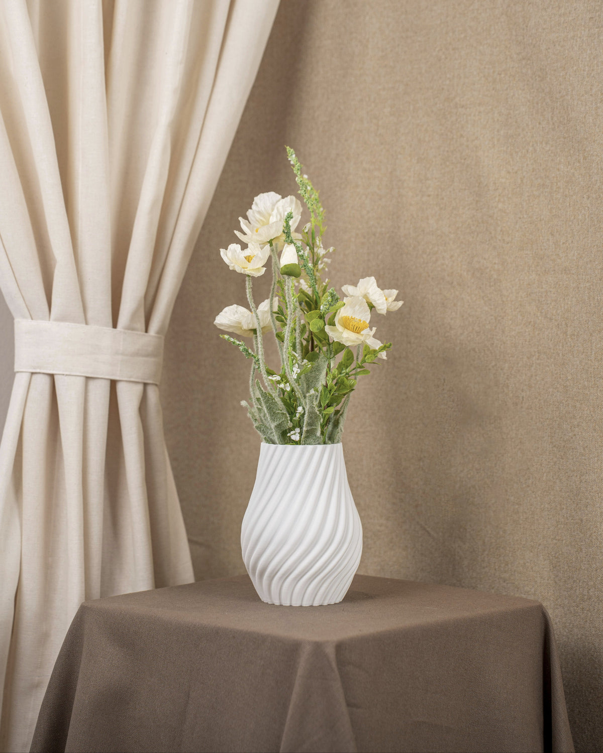 Vintervad Design Ida vase in white with a spiral textured surface, holding a bouquet of white flowers on a table.
