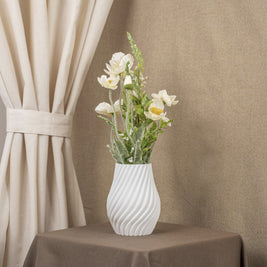 Vintervad Design Ida vase in white with a spiral textured surface, holding a bouquet of white flowers on a table.